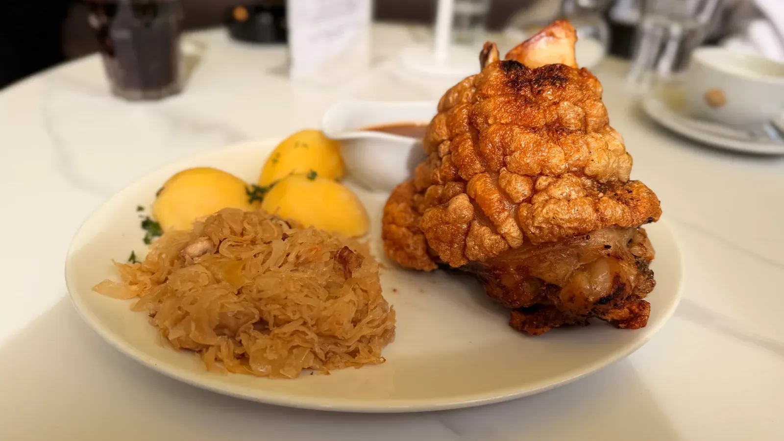 Schweinshaxe mit Sauerkraut und Klößen, serviert im Restaurant Adlermühle
