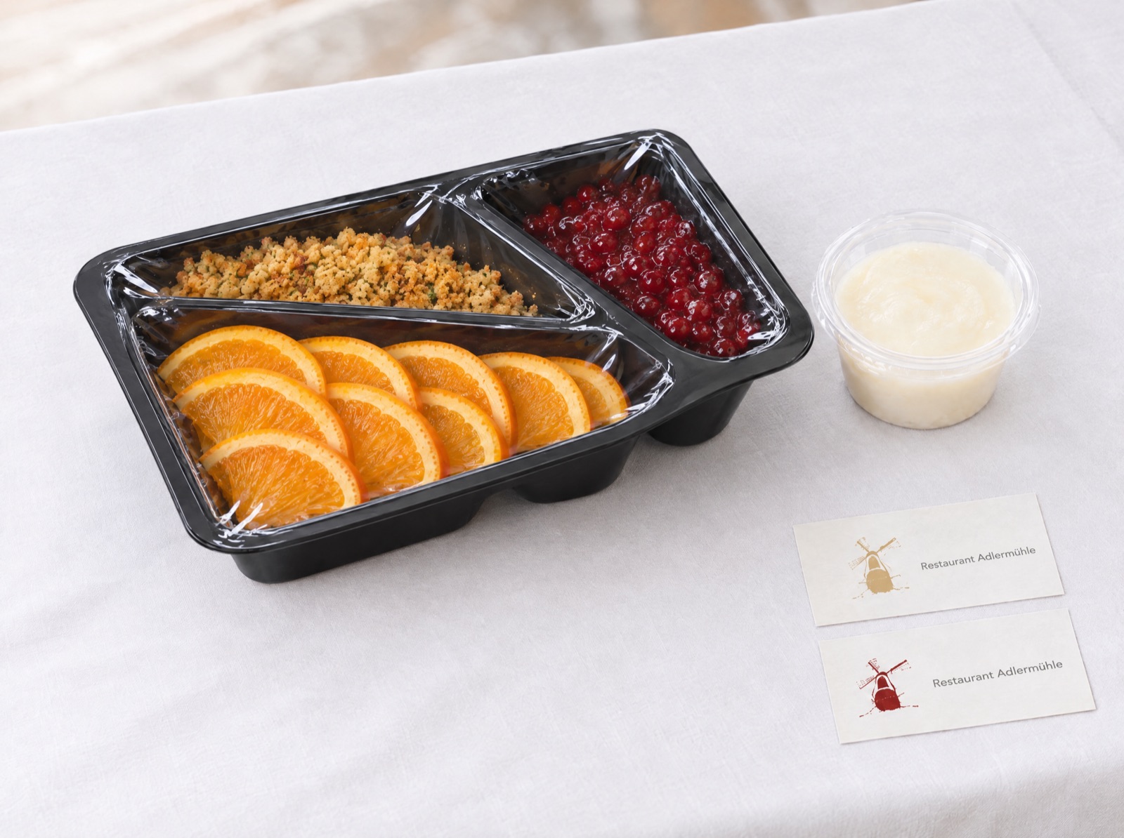 Orangenscheiben, Bröselbutter und Preiselbeeren in der Dreifach-Schale · Gänseschmalz im Becher