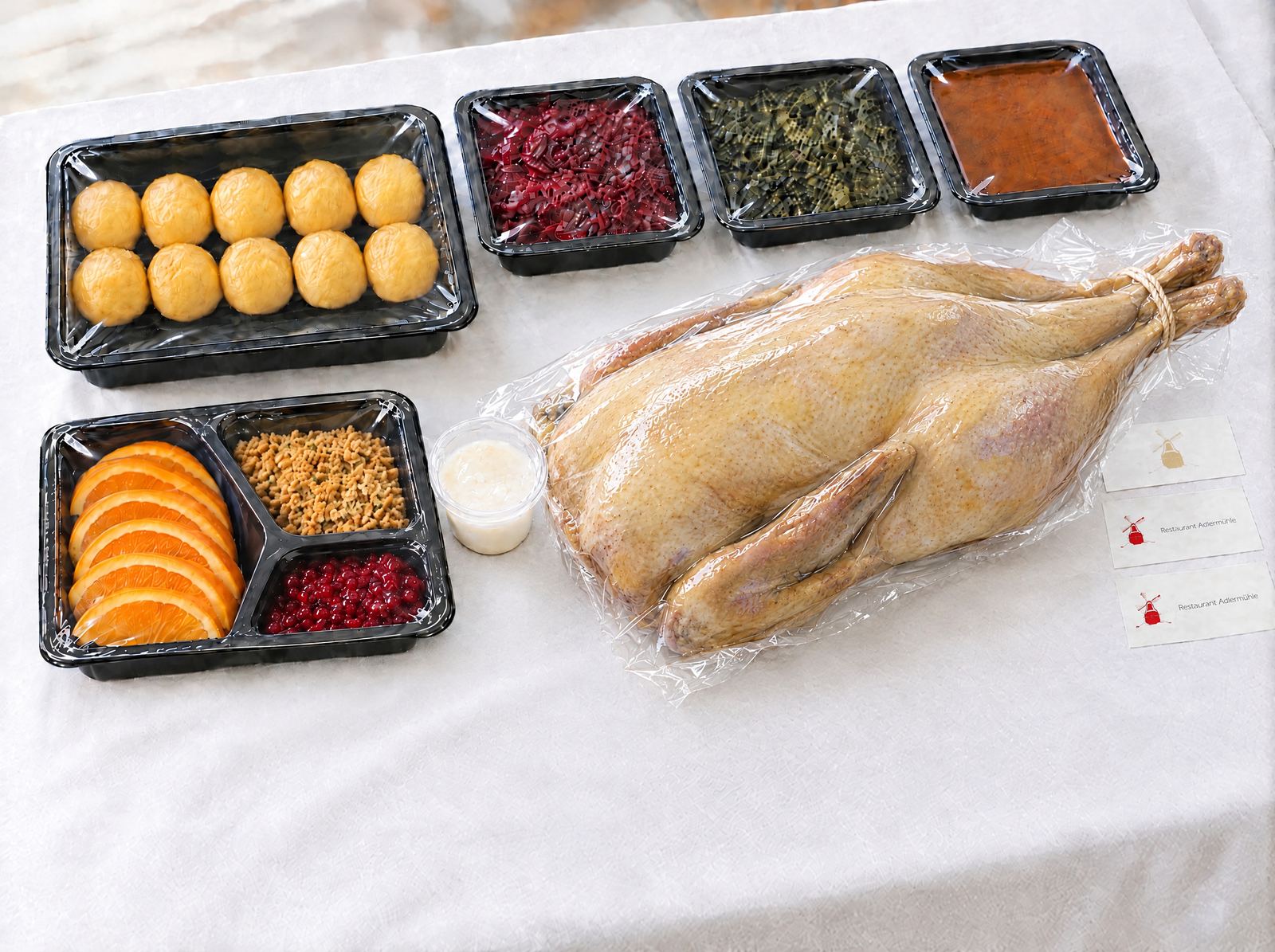 Lieferbeispiel ganze Gans: Gans vakuumiert, Klöße, Rotkohl, Grünkohl, Sauce, Dreifach-Schale und Schmalz